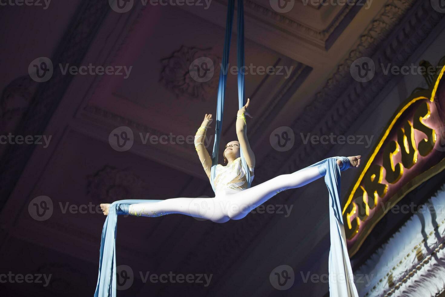 le fille effectue acrobatique Nombres sur le toiles. une petit cirque artiste effectue sur le toiles de acrobates. enfant effectuer acrobatique éléments dans le air photo