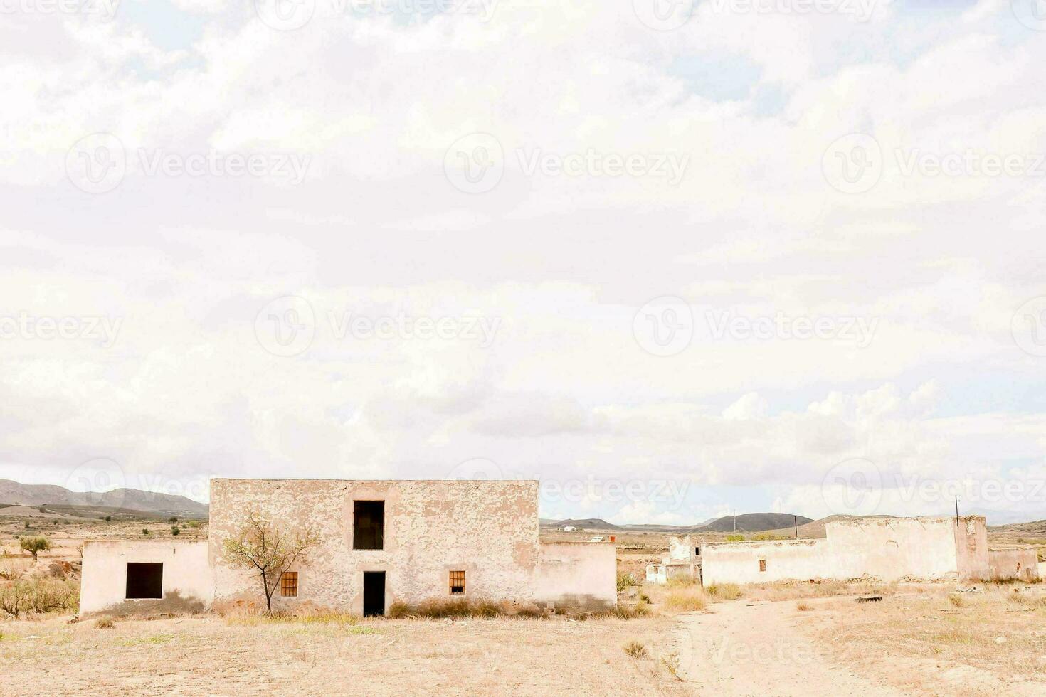 un vieux maison dans le désert avec une bleu ciel photo