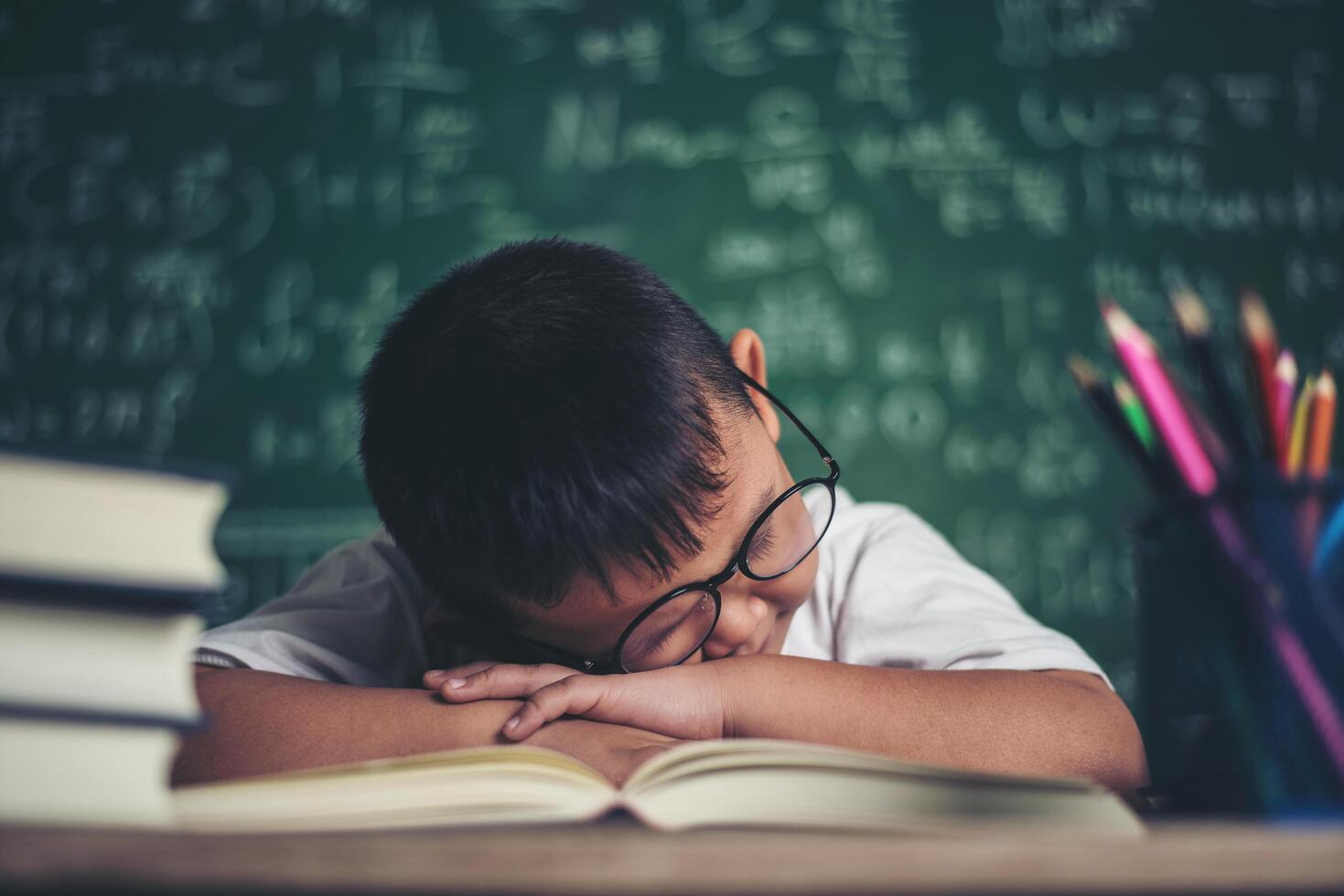 garçon dormant sur les livres dans la classe. photo