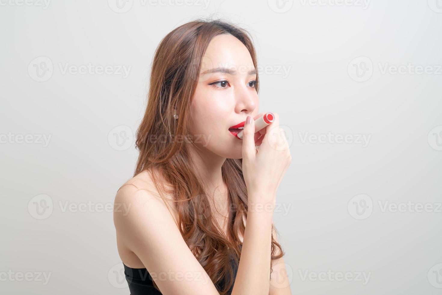 portrait belle femme maquillage et à l'aide de rouge à lèvres rouge photo