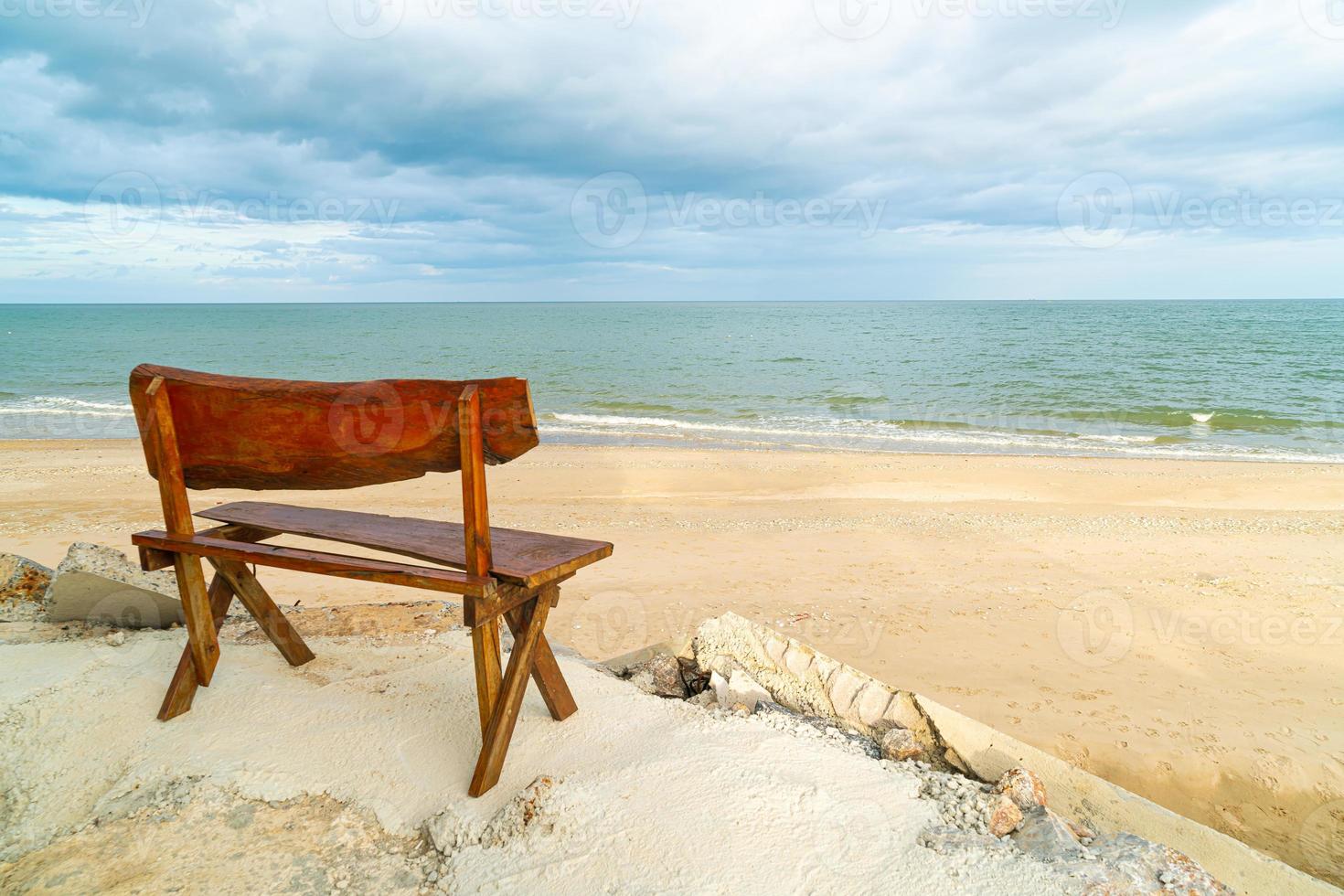 banc en bois sur la plage avec fond de plage de la mer photo