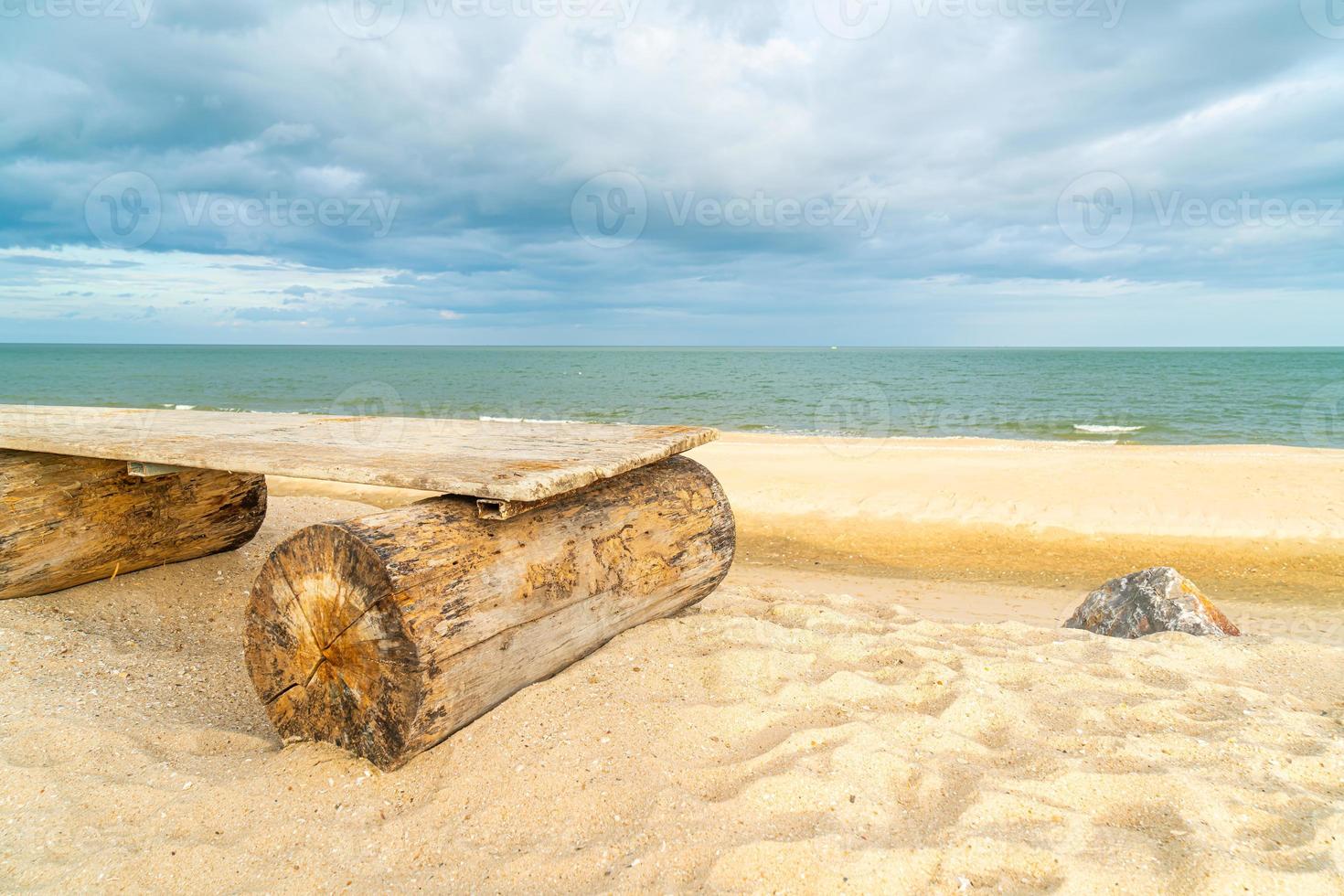 banc en bois sur la plage avec fond de plage de la mer photo