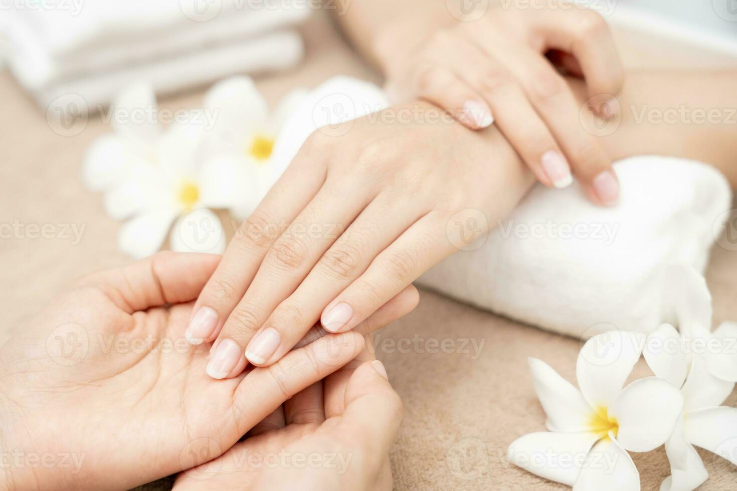 la femme reçoit un service de soins par une manucure esthéticienne professionnelle au centre de spa. salon de beauté des ongles utiliser une lime à ongles pour le traitement du vitrage. la manucure rend la cliente des ongles belle. soin du corps cure thermale photo