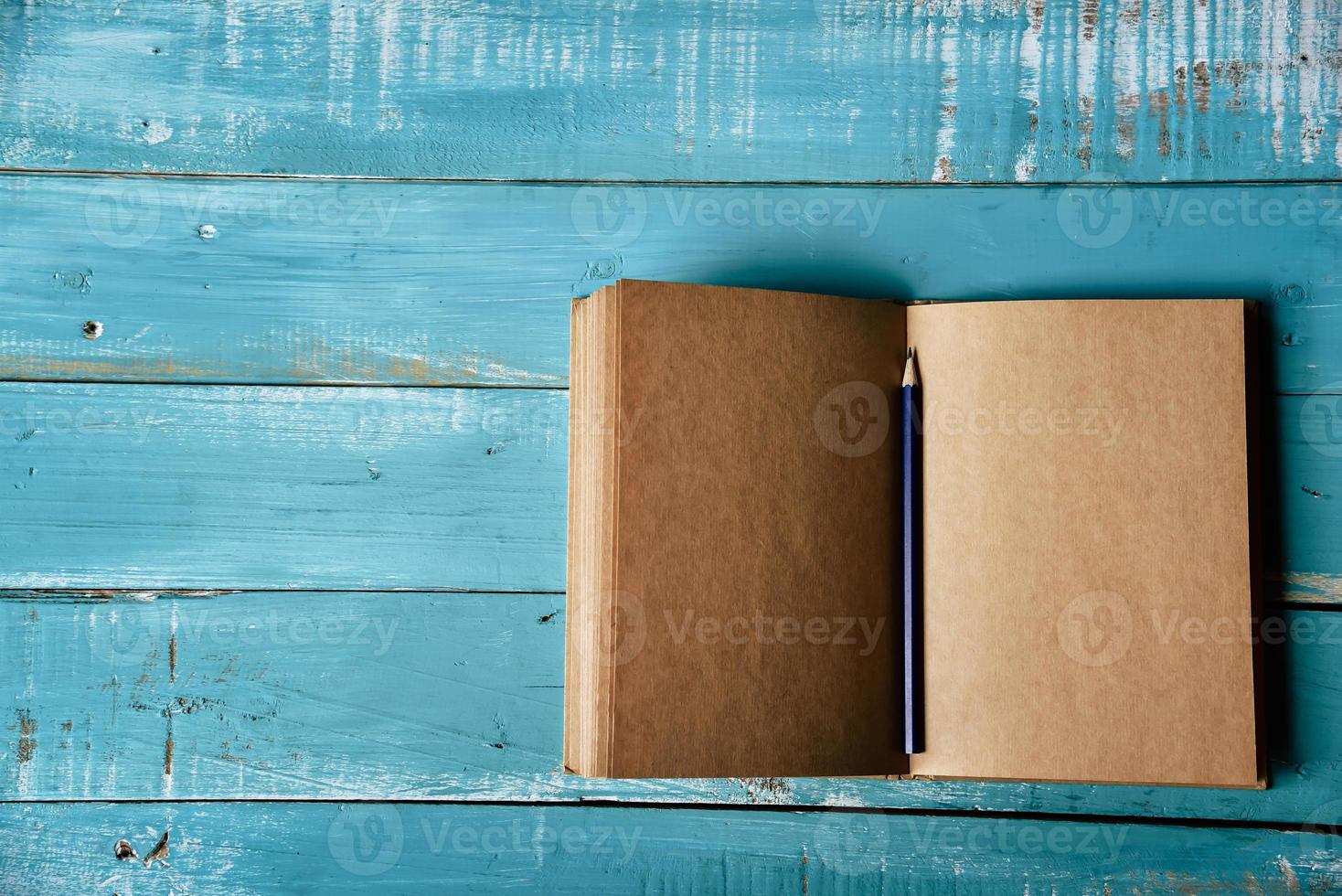 vue de dessus du cahier ouvert vierge sur fond de bois bleu photo