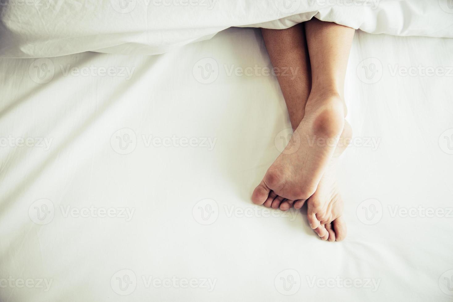 pieds nus de l'homme sur le lit le matin photo