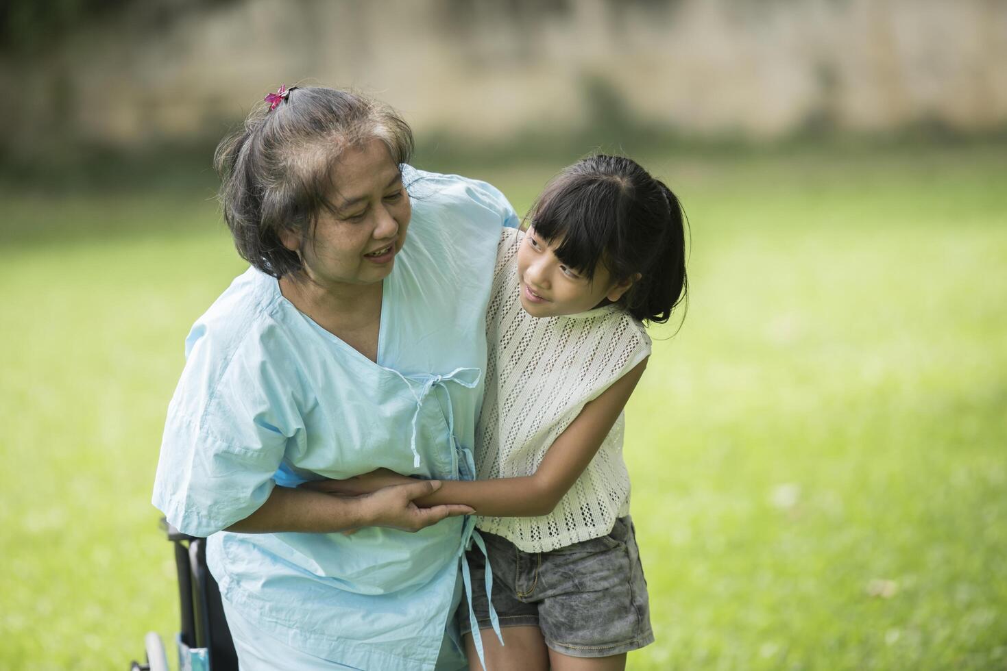 grand-mère âgée en fauteuil roulant avec sa petite-fille à l'hôpital photo