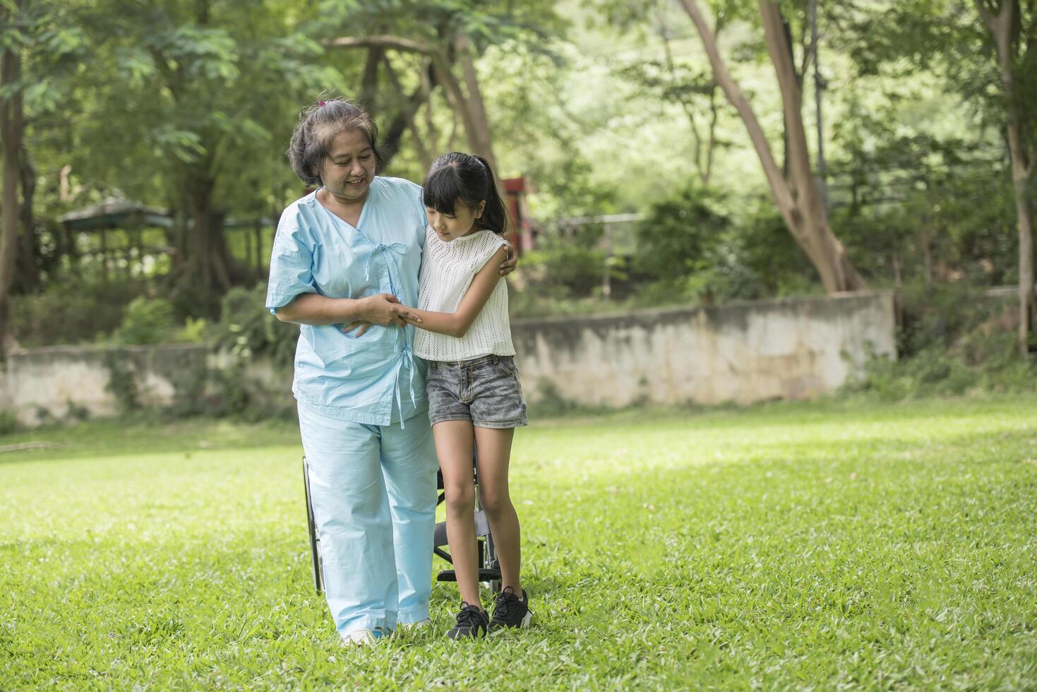 grand-mère âgée en fauteuil roulant avec sa petite-fille à l'hôpital photo