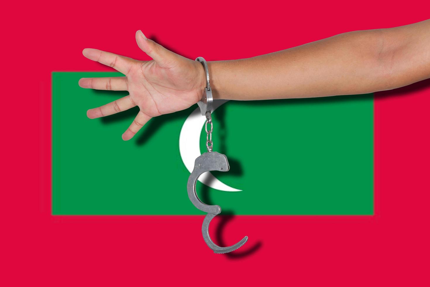 menottes à la main sur le drapeau des maldives photo