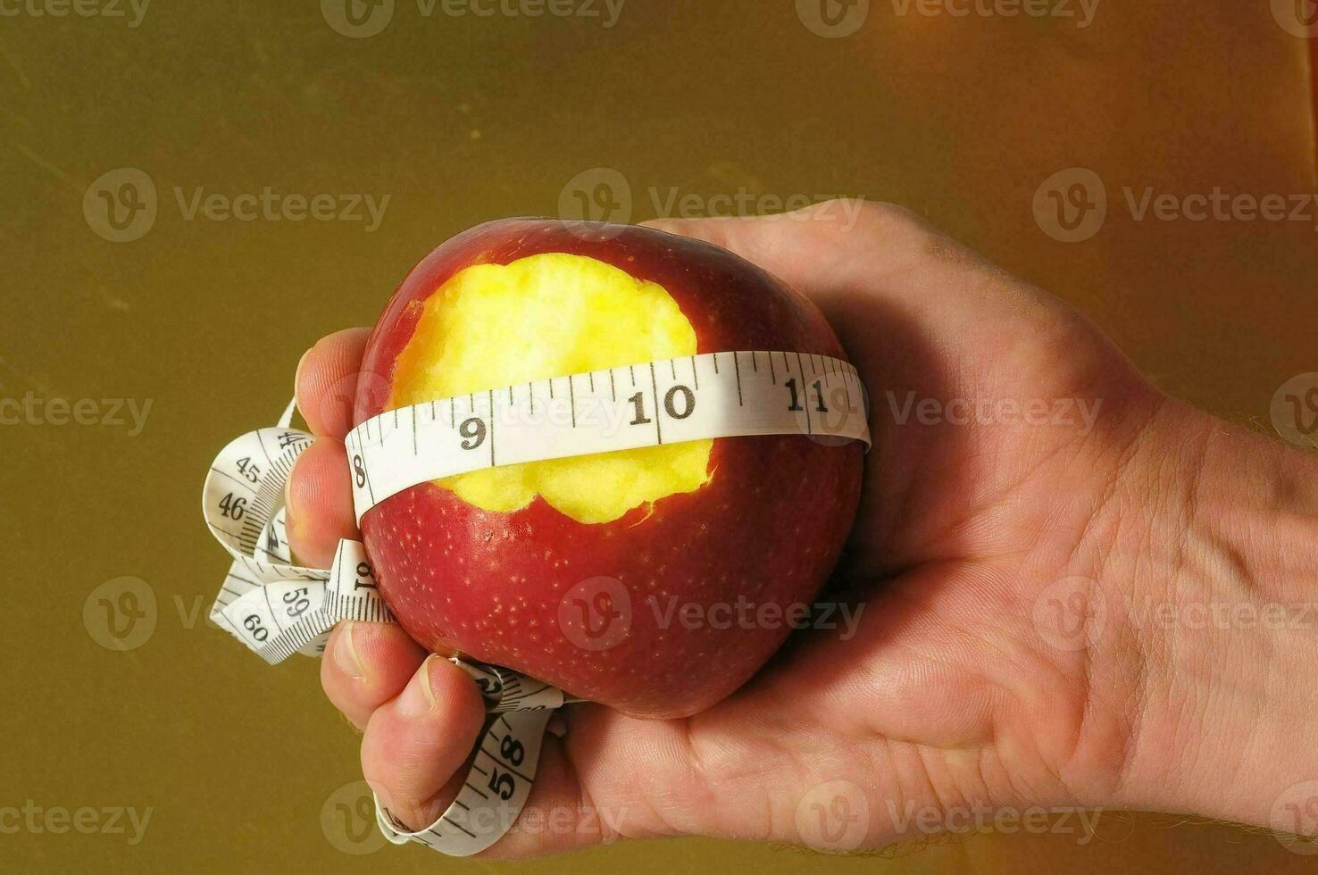 une la personne en portant un Pomme avec une mesure ruban autour il photo