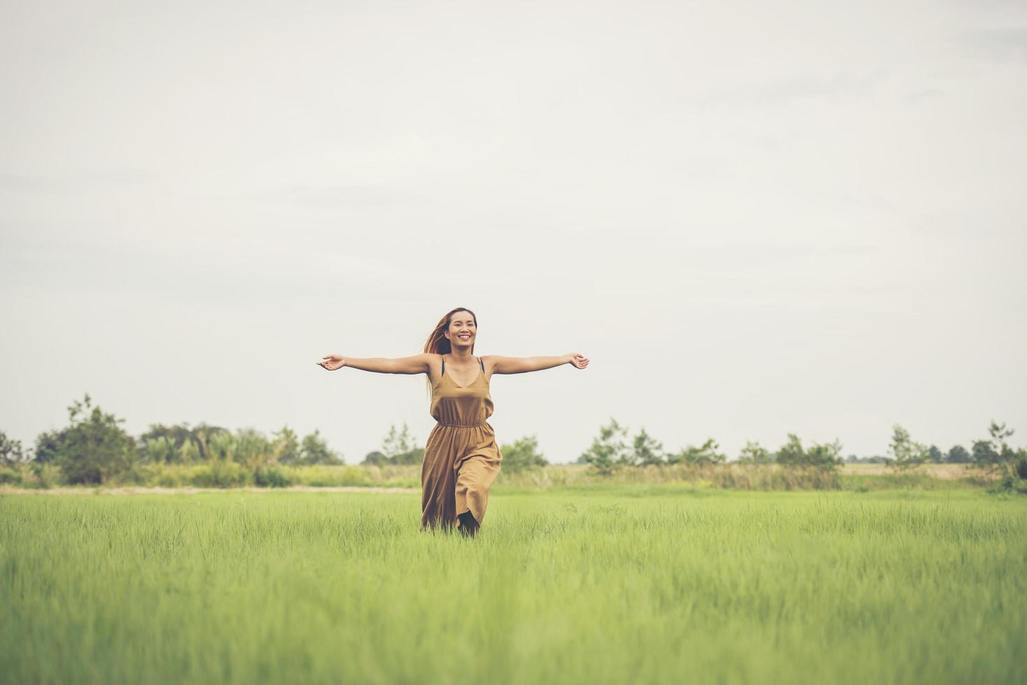 Happy woman running profiter au champ d'herbe photo