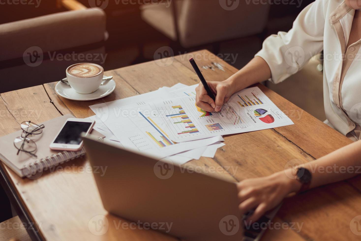 gros plan d'une femme d'affaires travaillant avec des documents et un ordinateur portable photo
