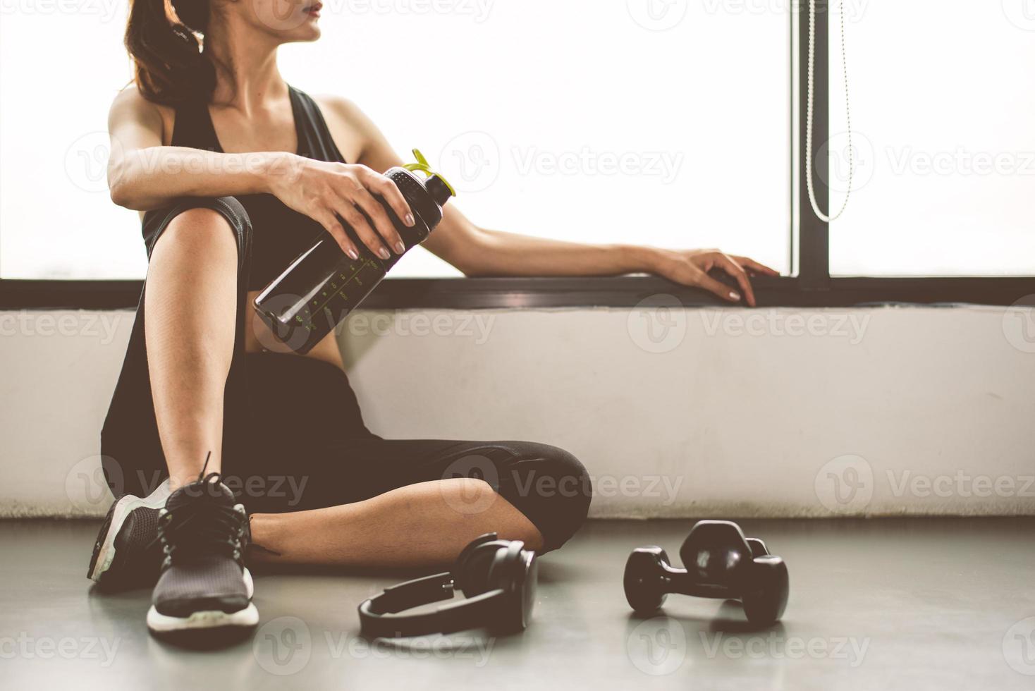 femme avec haltère et appareil d'entraînement de style de vie d'exercice dans la salle de sport photo