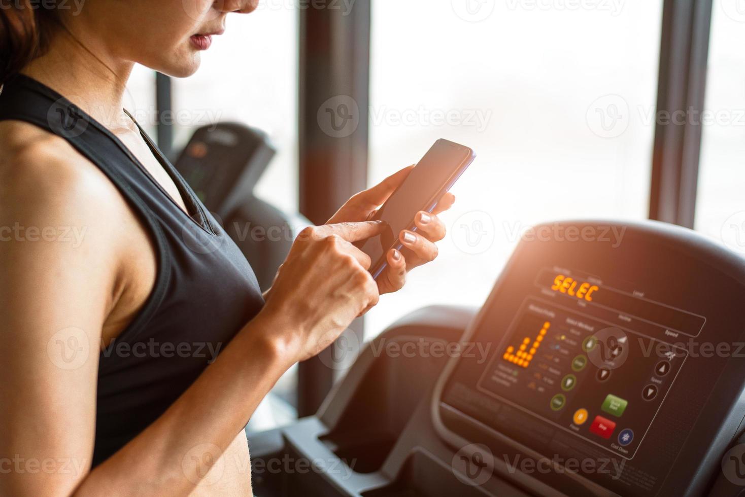 femme utilisant un téléphone intelligent lors de l'entraînement ou de la musculation photo