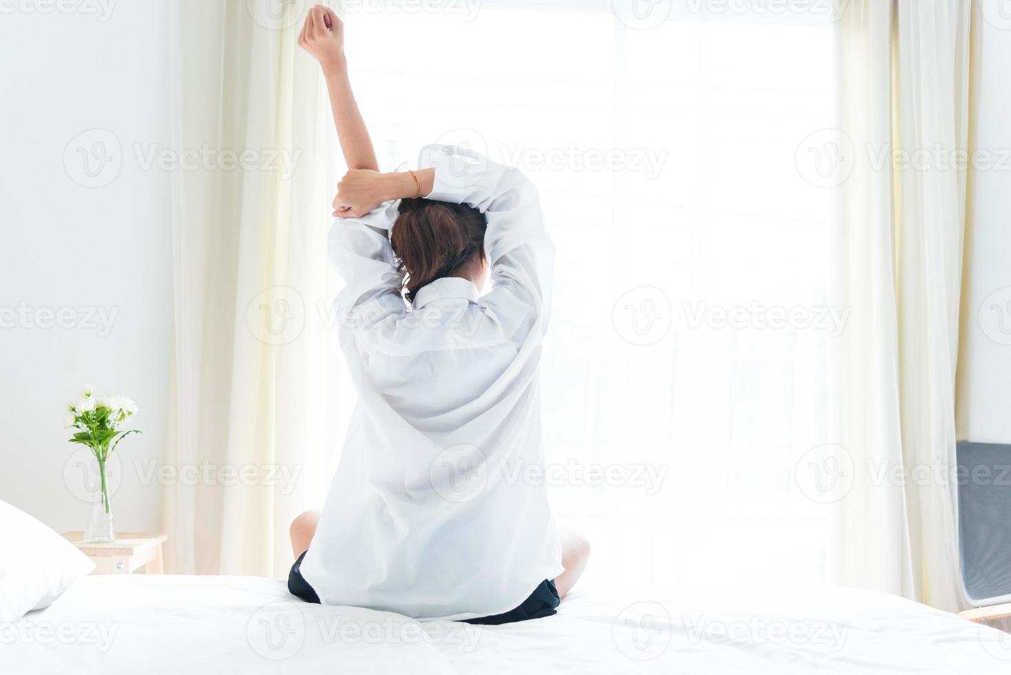 vue arrière de la femme qui s'étire le matin après le réveil photo