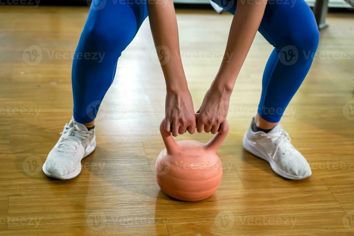 fermer et surgir Jeune femelle faire des exercices avec kettlebell poids dans aptitude centre. photo