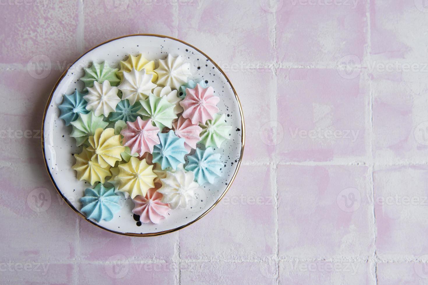 petites meringues colorées dans l'assiette en céramique photo