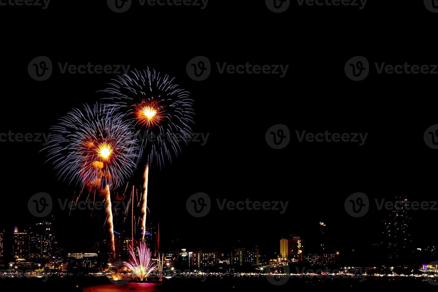 de nombreux feux d'artifice clignotants avec fond de paysage urbain de nuit nouvel an. photo