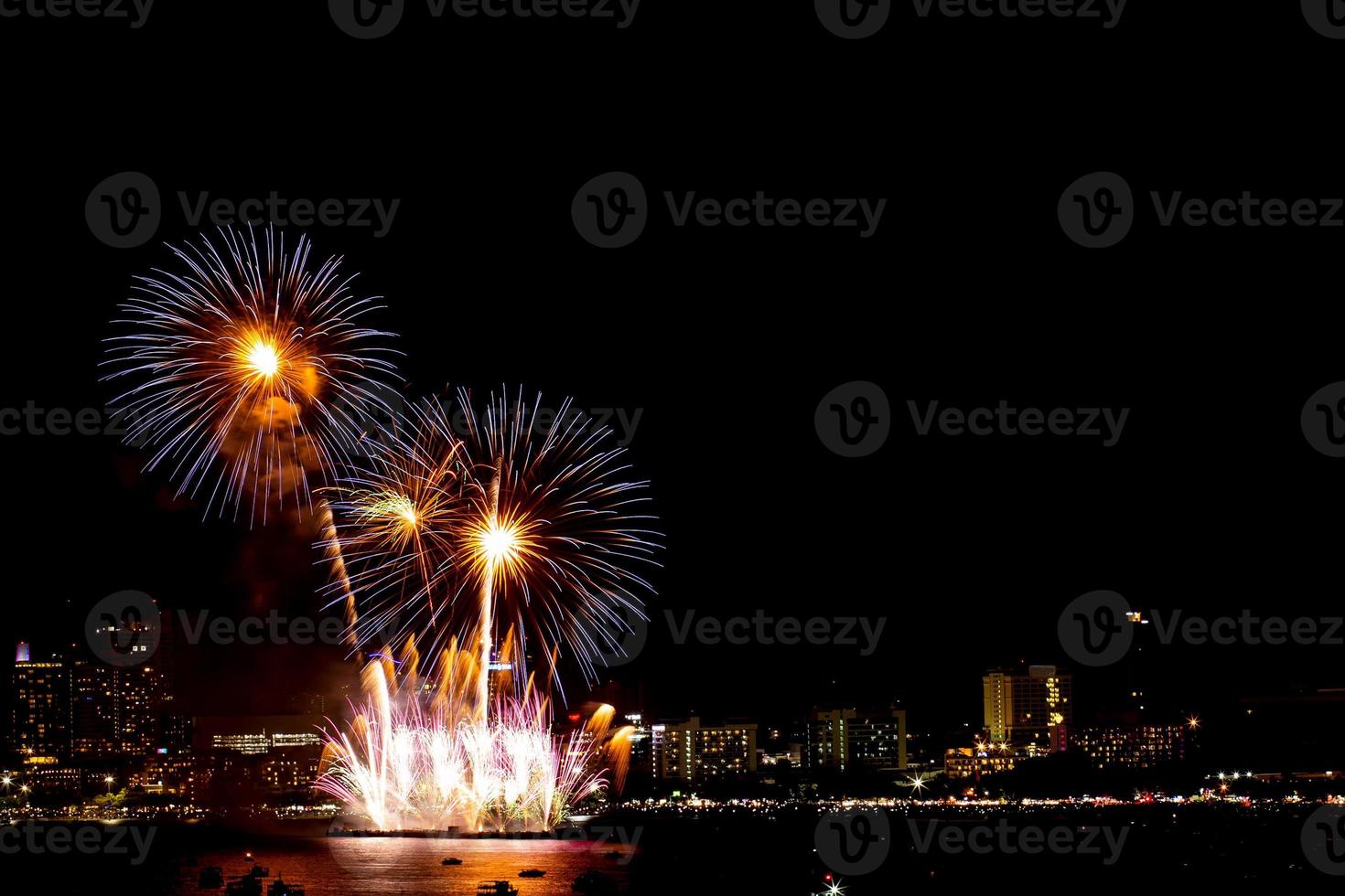 de nombreux feux d'artifice clignotants avec fond de paysage urbain de nuit nouvel an. photo