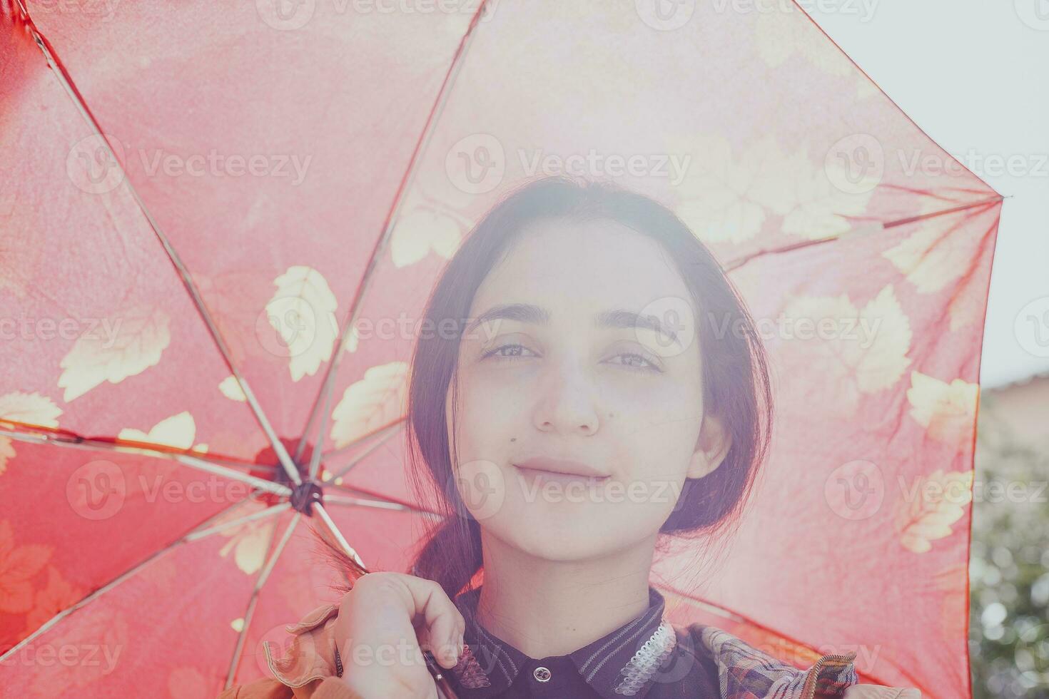 portrait de une jolie femme dans ensoleillé et chaud l'automne ou printemps journée posant avec le parapluie photo