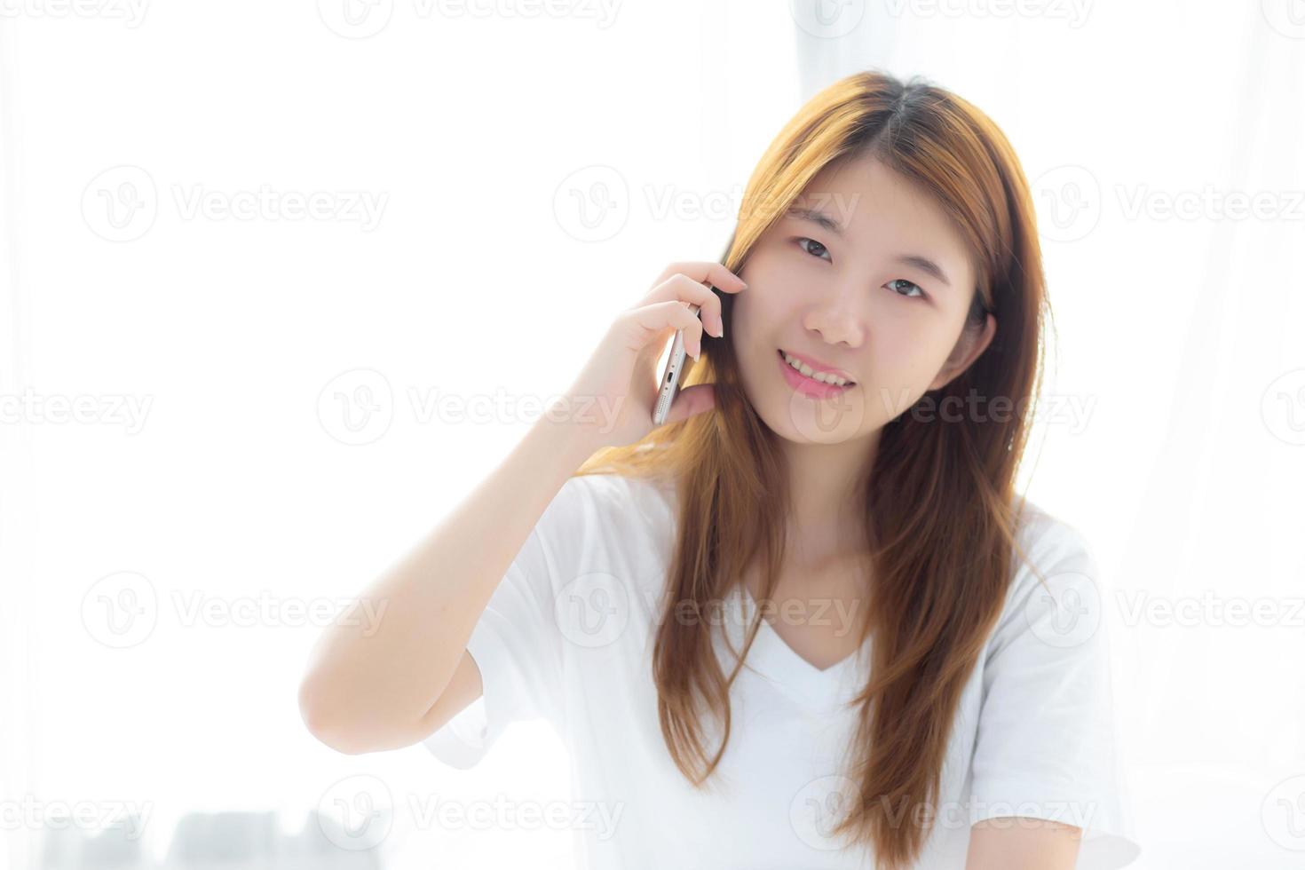 jeune femme asiatique souriante assise et se détendre sur le lit. photo