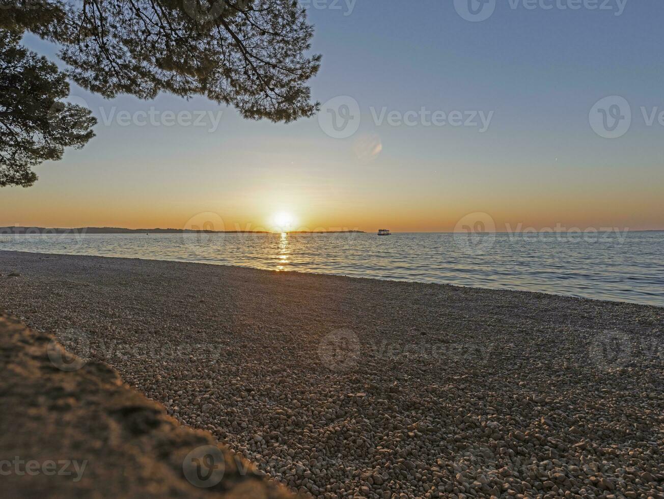 le coucher du soleil sur le plage dans le croate côtier ville de fazana photo