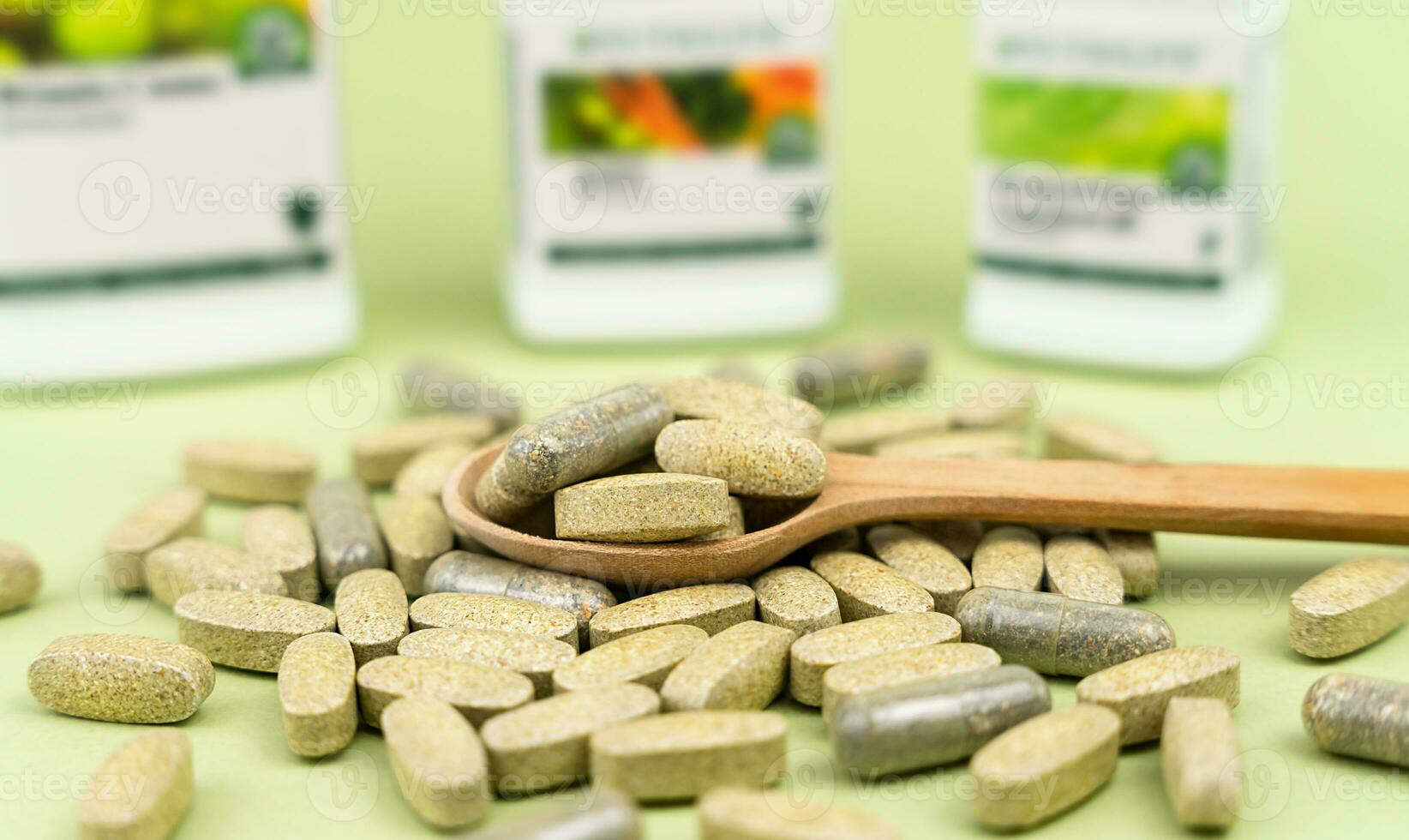 Naturel vitamines et suppléments dans une en bois cuillère sur une vert Contexte. fermer. sélectif se concentrer. photo