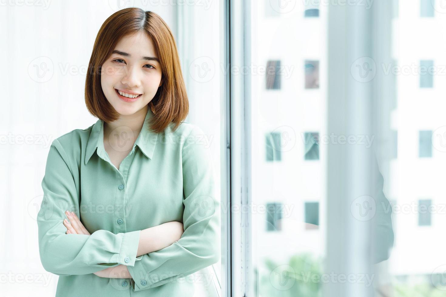 portrait de jeune femme d'affaires debout près de la fenêtre de l'entreprise photo