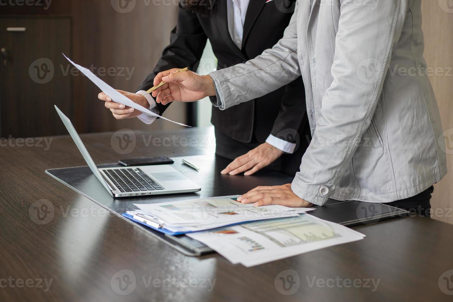 femme d'affaires et homme d'affaires analysant des documents photo