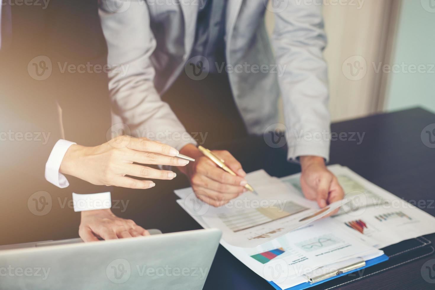 femme d'affaires et homme d'affaires analysant des documents photo