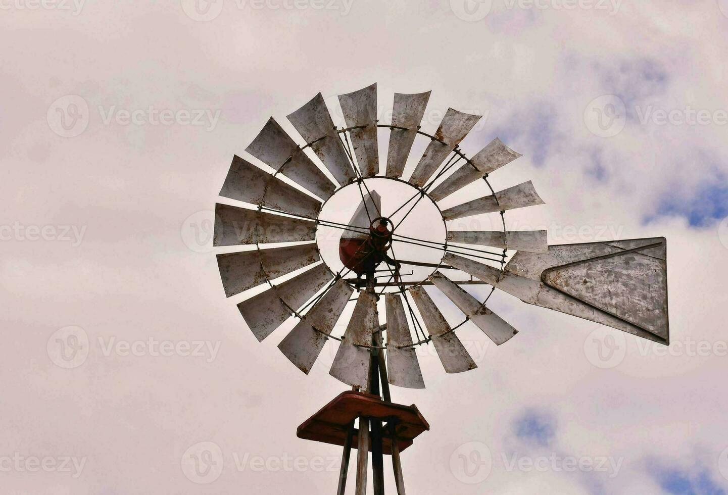 une Moulin à vent avec une métal pôle et une métal toit photo