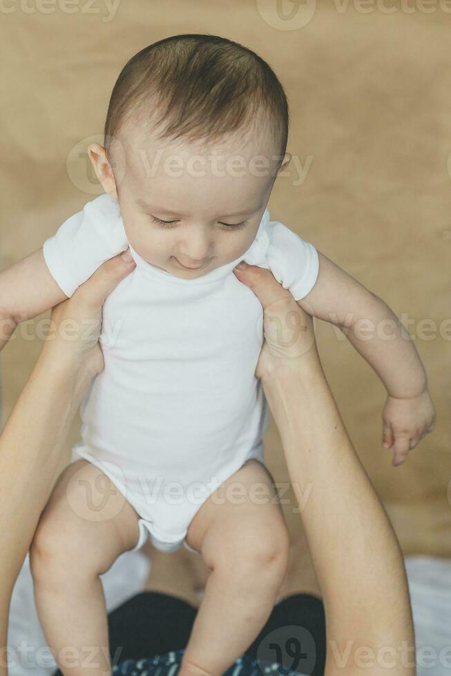 mère et bébé. maman en portant sa 6 mois bébé garçon. magnifique bébé garçon de six mois dans le sien de la mère mains. Jeune milieu est mère en portant dans sa bras sa peu fils photo