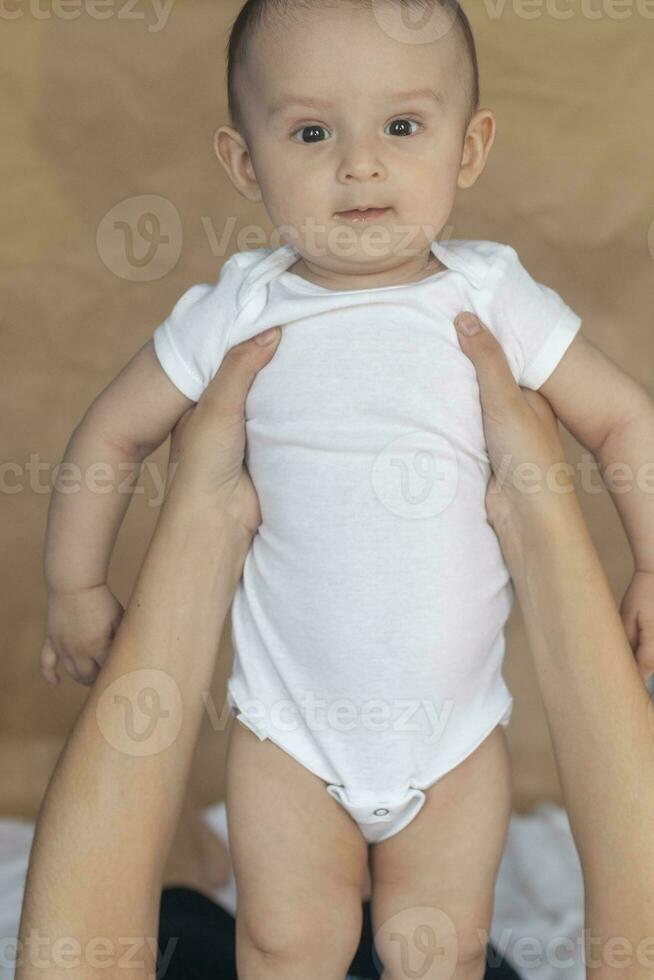 mère et bébé. maman en portant sa 6 mois bébé garçon. magnifique bébé garçon de six mois dans le sien de la mère mains. Jeune milieu est mère en portant dans sa bras sa peu fils photo