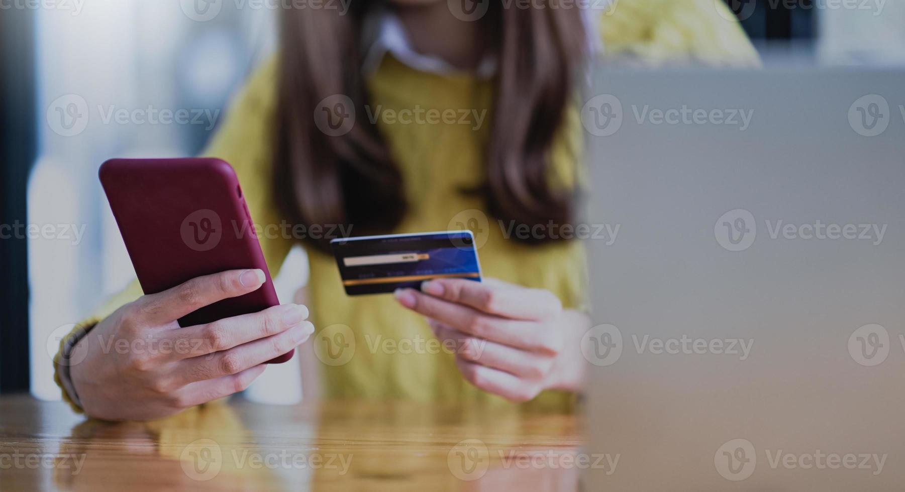 jeune femme payant en ligne par smartphone et carte de crédit. photo
