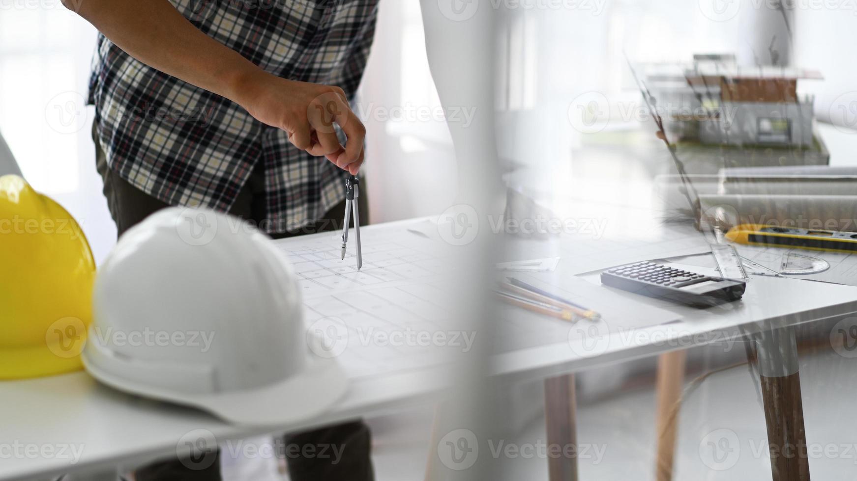 les concepteurs utilisent des boussoles pour dessiner des dessins sur des plans de maison. photo