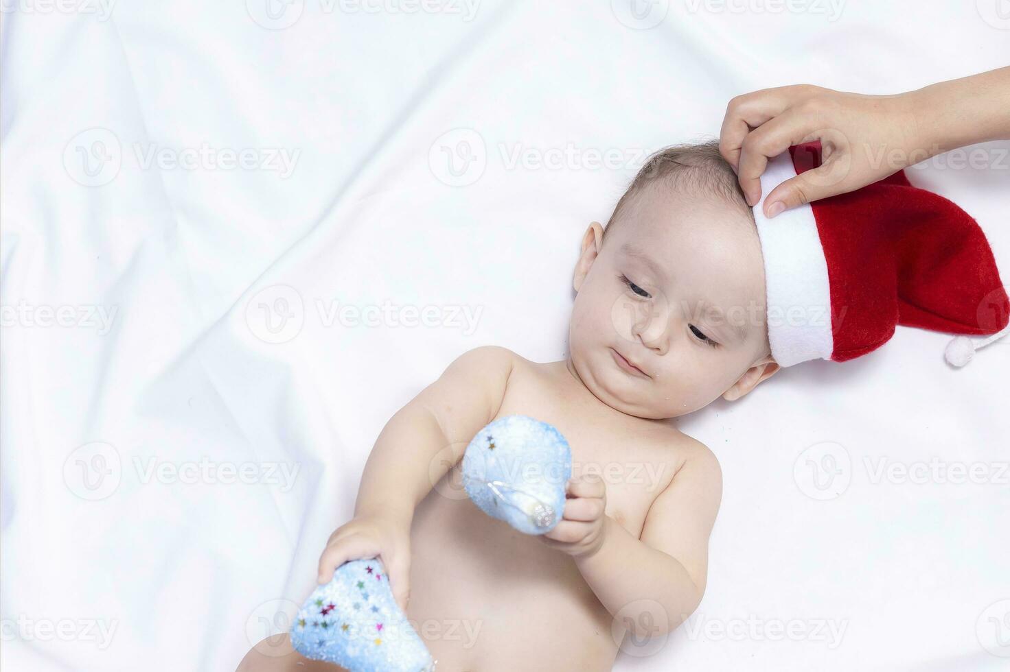 9 mois bébé garçon avec Père Noël claus chapeau. Noël Matin. peu enfant jouant. photo