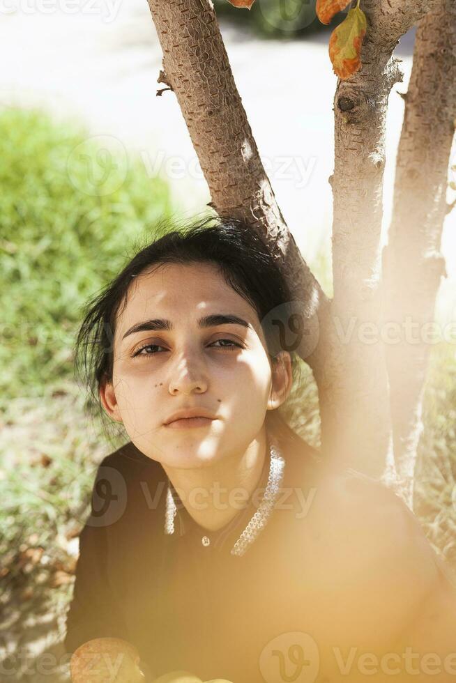 portrait de magnifique moyen-orient femme à Pomme jardin. Jeune femelle posant à le la nature photo