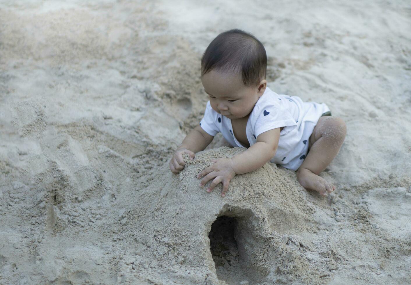 asiatique bambin bébé thaïlandais fille en jouant avec le sable photo