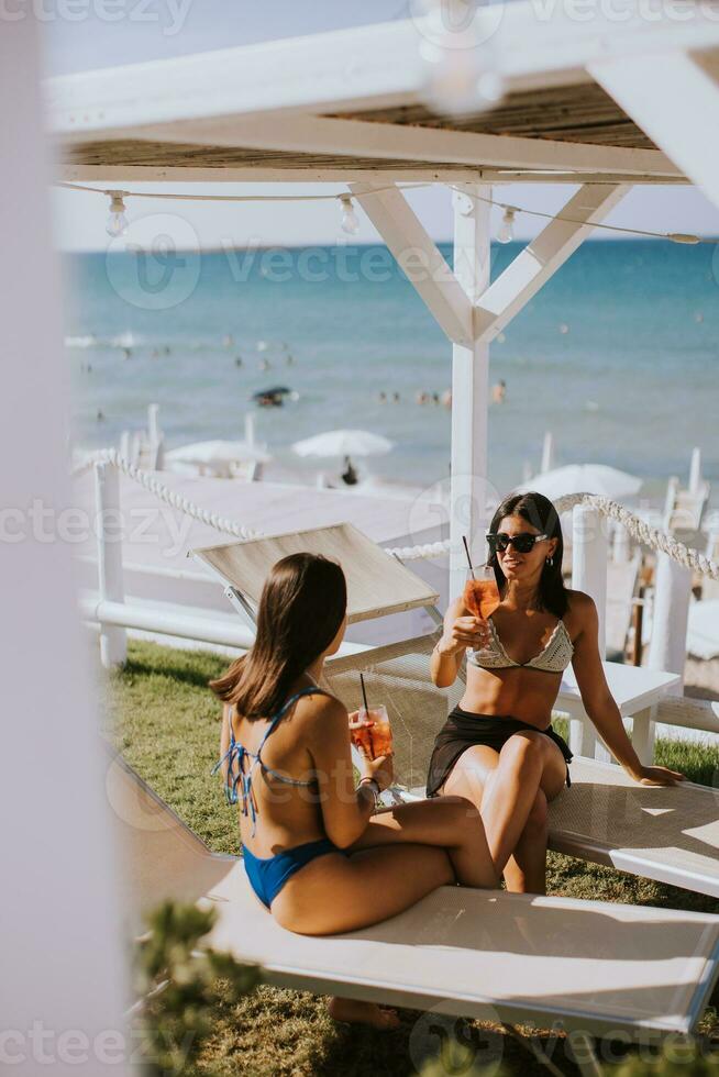 souriant Jeune femmes dans bikini profiter vacances sur le plage photo