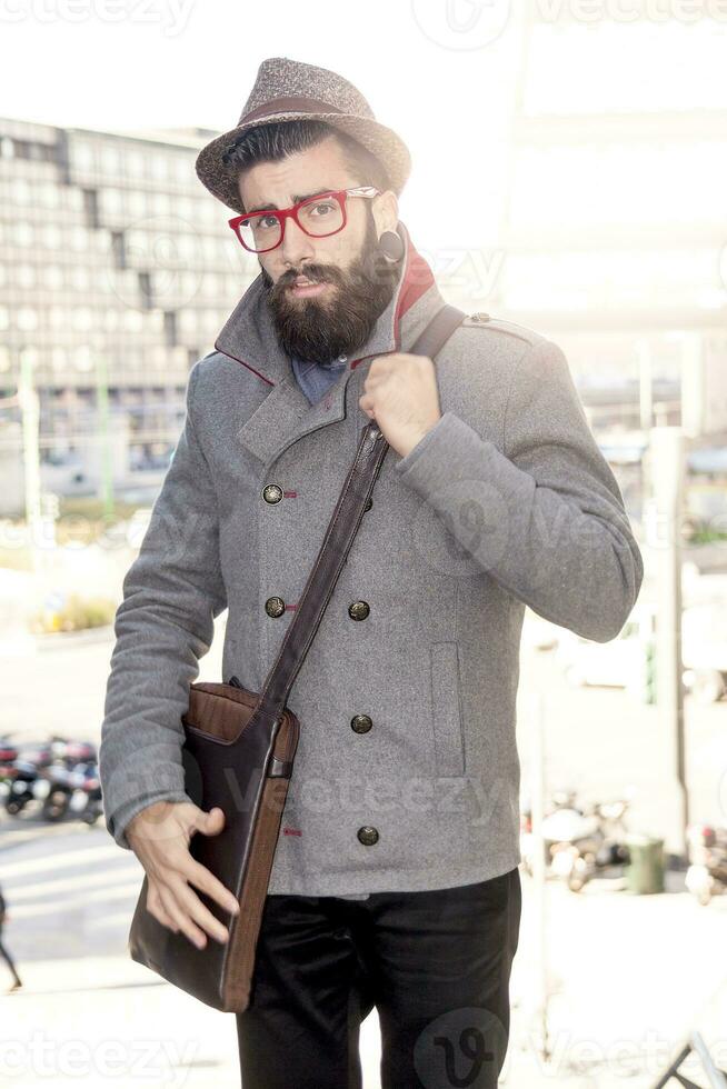 Jeune branché homme d'affaire consulte le sien portable dans le cœur de ville photo