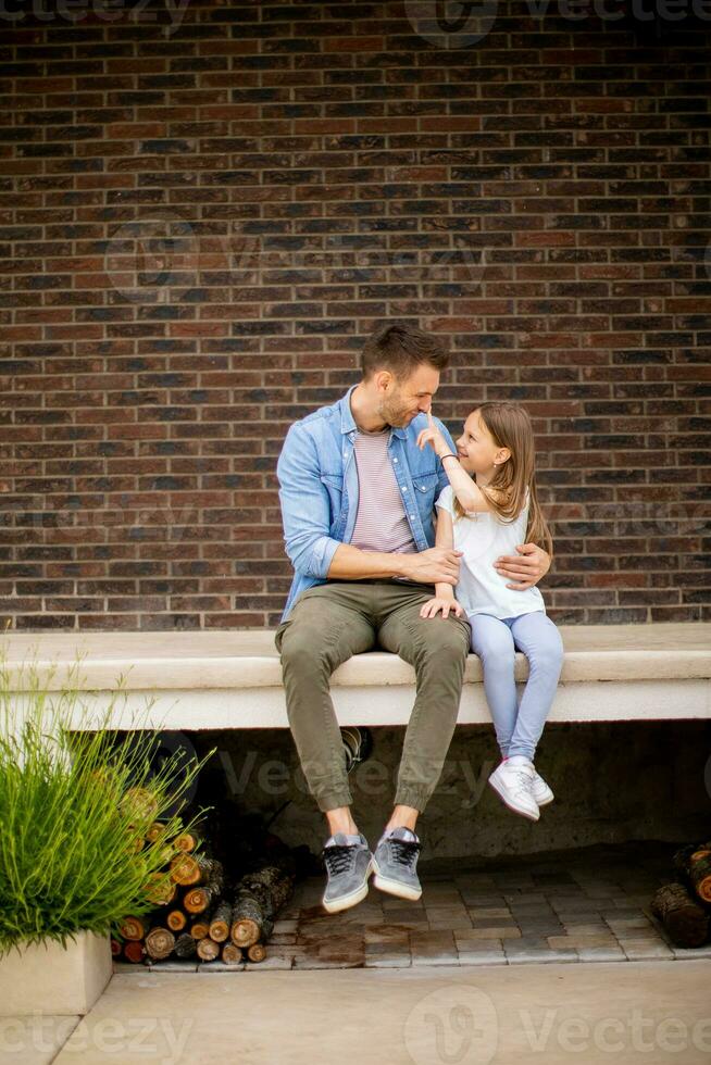 père et le sien fille avoir une bien temps dans de face de maison porte photo