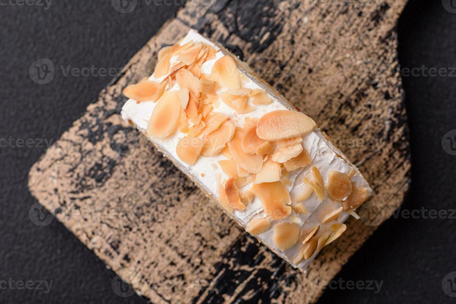 une pièce de délicieux sucré Meringue rouleau avec mascarpone fromage, baies et amandes photo