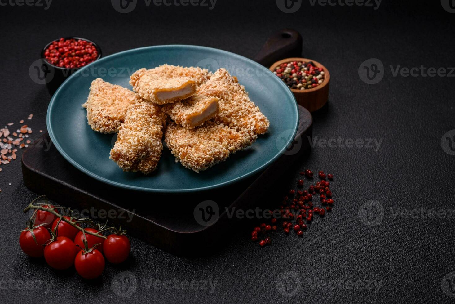 De délicieuses pépites de poulet croustillant frais sur un fond de béton foncé photo
