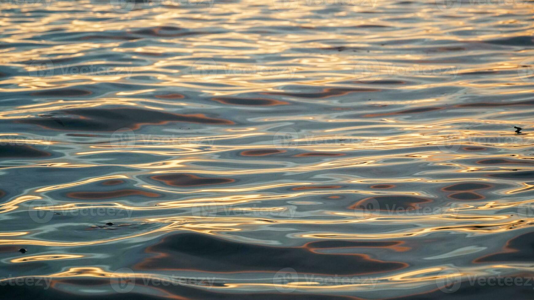 ondulations sur le l'eau surface de le mer, le coucher du soleil couleurs, Haut vue photo