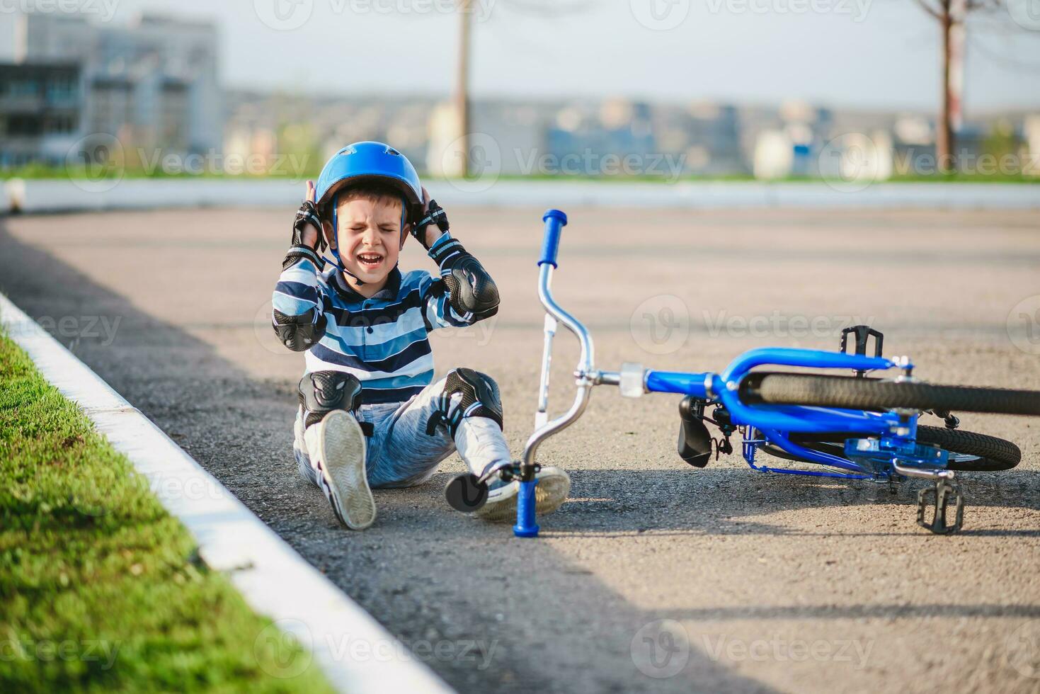 une petit enfant est tombée de une vélo sur le route, pleurs et en hurlant dans douleur. photo