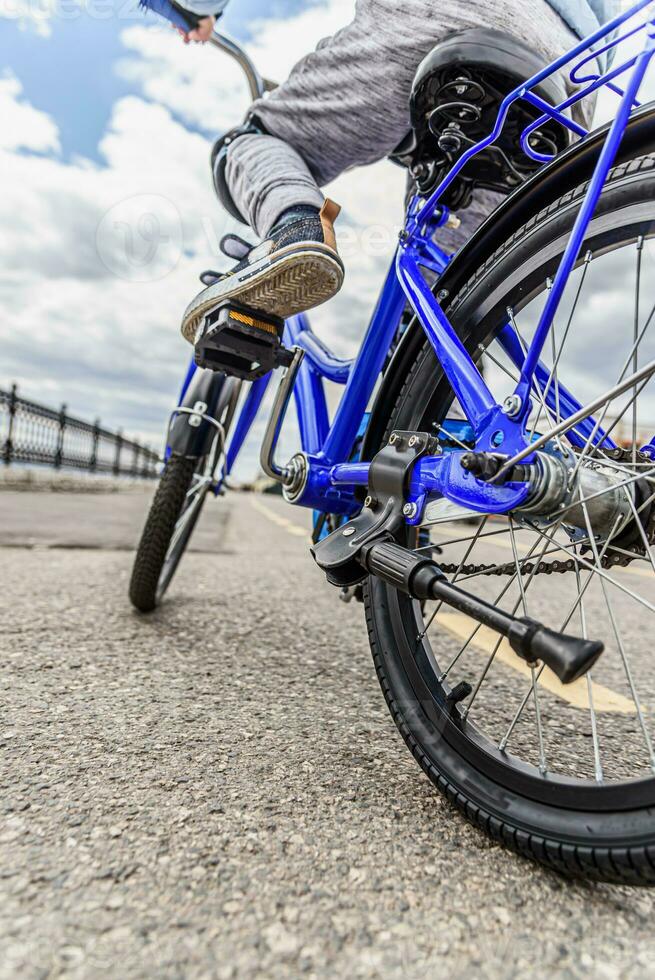 une enfant dans une casque et protection dans une bicyclette balade sur la nature dans le printemps photo