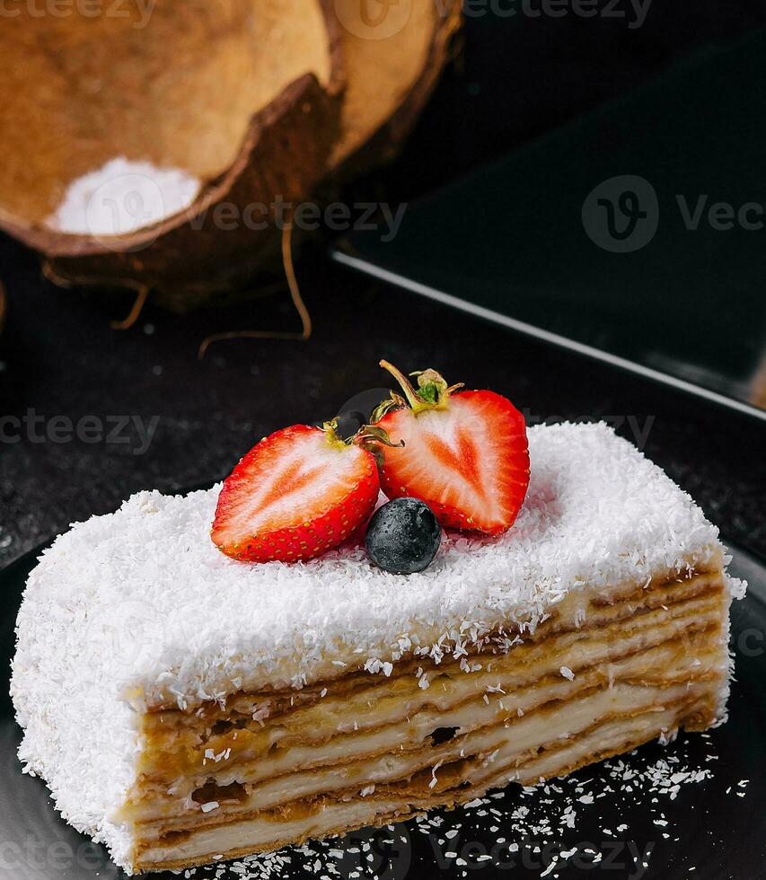 noix de coco gâteau tranche avec des fraises et myrtilles photo