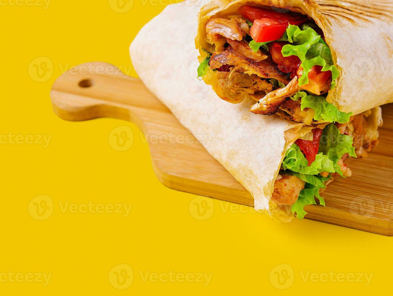 shawarma avec poulet, tomates et salade sur une en bois planche photo