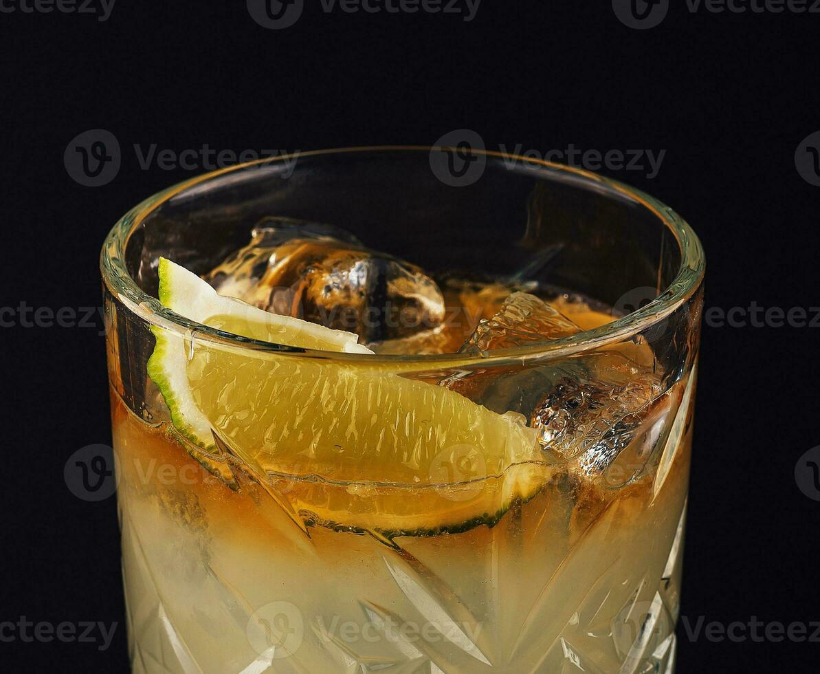 Jaune boisson avec citron vert sur foncé Contexte photo