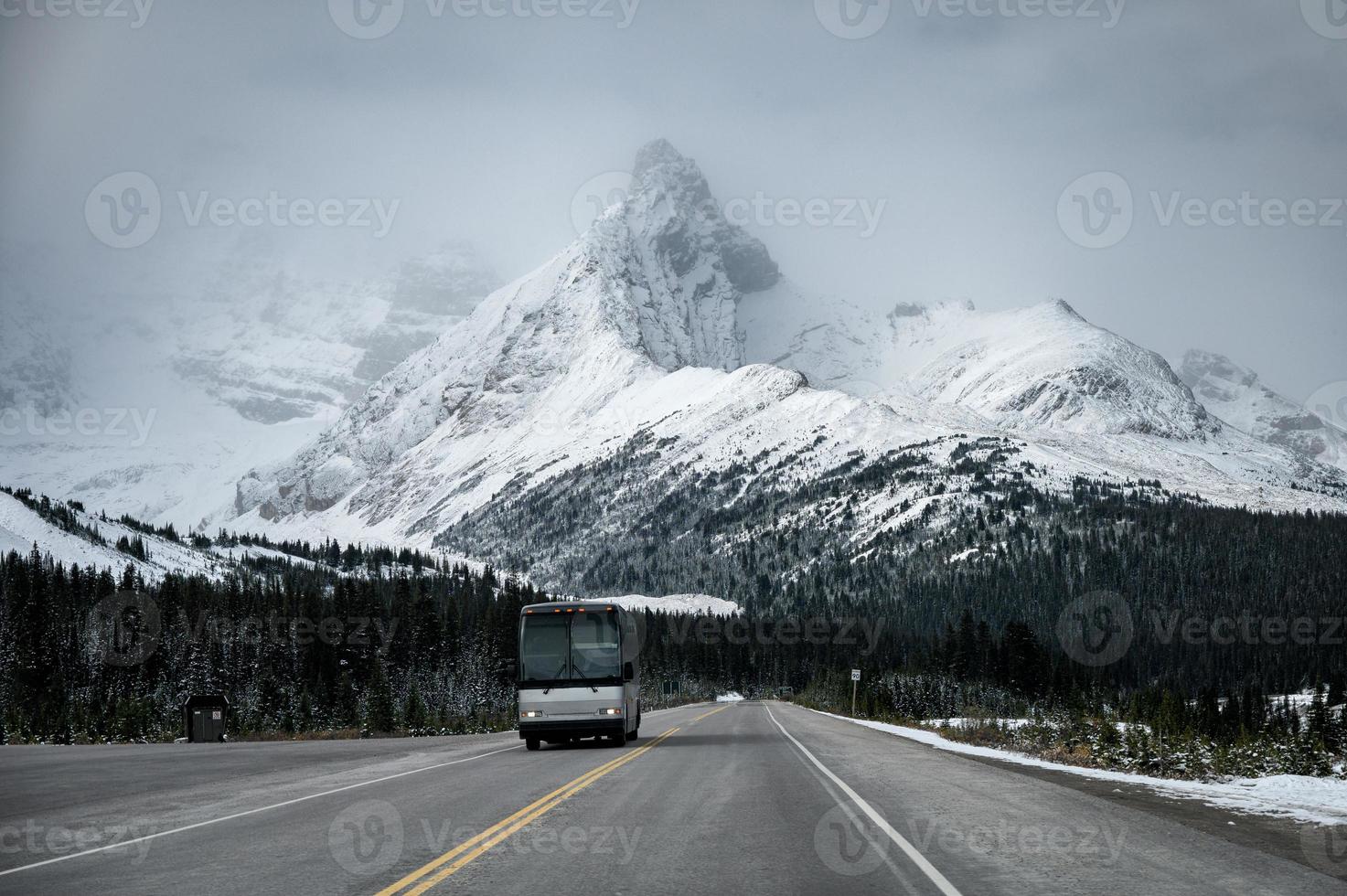 bus roulant sur route goudronnée avec grand fond de montagne de neige photo