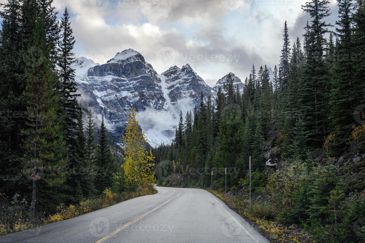 conduite sur route dans une forêt de pins avec des montagnes rocheuses au lac moraine photo